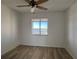 Bright bedroom featuring wood-look floors, ceiling fan, and a window with a view at 3993 Lake Bayshore Dr # F513, Bradenton, FL 34205