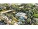 A high-angle view of the home featuring a screened lanai, mature trees and lush surroundings at 611 Mobile Rd, Venice, FL 34293