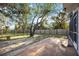 View of backyard with mature trees and a tiled patio at 611 Mobile Rd, Venice, FL 34293