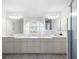 Bright primary bathroom features double vanity sinks, modern lighting, and white tile floors at 611 Mobile Rd, Venice, FL 34293