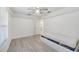 Bright bedroom features neutral walls, wood-look flooring, a ceiling fan, underbed storage and closet access at 611 Mobile Rd, Venice, FL 34293