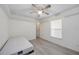 Bright bedroom features neutral walls, wood-look flooring, a ceiling fan and a window with blinds at 611 Mobile Rd, Venice, FL 34293
