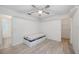 Bright bedroom features neutral walls, wood-look flooring, a ceiling fan, underbed storage and closet access at 611 Mobile Rd, Venice, FL 34293