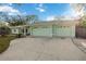 Front exterior of home showing a large concrete driveway and light green painted garage doors at 611 Mobile Rd, Venice, FL 34293