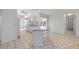 Inviting kitchen with breakfast bar, white cabinets, tile flooring, and easy access to other rooms at 611 Mobile Rd, Venice, FL 34293