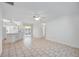 Open-concept living area with tile flooring, white walls, ceiling fan, and sliding glass doors to the lanai at 611 Mobile Rd, Venice, FL 34293