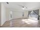 Bright living room featuring wood floors, ceiling fan, natural light, and sliding glass doors to the pool at 611 Mobile Rd, Venice, FL 34293