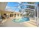 This is an in-ground screened pool, next to an outdoor seating area, and a pair of sliding glass doors to the home at 611 Mobile Rd, Venice, FL 34293