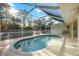 View of the screened pool with a unique design and a large, surrounding deck at 611 Mobile Rd, Venice, FL 34293