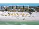 Beachfront property with numerous yellow umbrellas and lounge chairs at 915 Seaside Dr # 407, Sarasota, FL 34242
