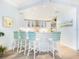 Modern white kitchen with a breakfast bar and stainless steel appliances at 915 Seaside Dr # 407, Sarasota, FL 34242