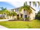 Two-story house with a tan exterior, landscaping, and palm trees in the front yard at 4010 91St E Ave, Parrish, FL 34219