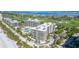 Aerial view showcasing condo complex, pool, golf course, and bay at 535 Sanctuary Dr # A202, Longboat Key, FL 34228