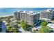 Aerial view of luxurious beachfront condo building with ocean and landscape views at 535 Sanctuary Dr # A202, Longboat Key, FL 34228