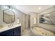 Elegant bathroom with a soaking tub, quartz countertop, and blue vanity at 535 Sanctuary Dr # A202, Longboat Key, FL 34228