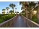 Wooden boardwalk winds through tropical foliage to beach at 535 Sanctuary Dr # A202, Longboat Key, FL 34228