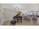 Bright living room features hardwood floors, a grand piano, and access to a balcony at 535 Sanctuary Dr # A202, Longboat Key, FL 34228