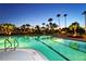 Night view of resort-style pool with palm trees at 535 Sanctuary Dr # A202, Longboat Key, FL 34228