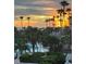 Stunning sunset view over the ocean and palm trees from condo balcony at 535 Sanctuary Dr # A202, Longboat Key, FL 34228