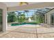 Spacious pool area with covered patio, overlooking a tranquil lake at 7816 Crest Hammock Way, Sarasota, FL 34240