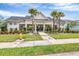 Community clubhouse featuring a covered entryway, meticulous landscaping, and manicured lawn at 3819 Sunshine Pine Ave, Bradenton, FL 34203