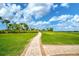 Paved pathway winds through lush green lawn with palm trees and gazebo at 4734 Tortona Ct, Bradenton, FL 34211