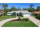Single-story home with a three-car garage and landscaped yard at 7917 Broadmoor Pines Blvd, Sarasota, FL 34243