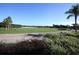 Golf course view with palm trees and residential buildings in background at 7914 Grand Estuary Trl # 102, Bradenton, FL 34212