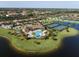 Resort-style pool and tennis courts with clubhouse in background at 7914 Grand Estuary Trl # 102, Bradenton, FL 34212