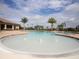 Community pool with palm trees and lounge chairs at 7914 Grand Estuary Trl # 102, Bradenton, FL 34212