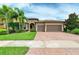 Two-story house with tile roof, three car garage, and landscaped yard at 11192 Whimbrel Ln, Sarasota, FL 34238
