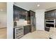 Modern kitchen with dark cabinetry, granite counters, and wine cooler at 11192 Whimbrel Ln, Sarasota, FL 34238