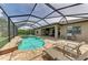 Freeform pool and spa with screened enclosure, patio, and lounge chairs at 11192 Whimbrel Ln, Sarasota, FL 34238