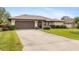 Single story home with brown garage door and large front yard at 1478 Navigator Rd, Punta Gorda, FL 33983