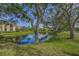 Pond-side view of homes with lush trees and landscaping at 4028 Mira Lago Dr, Sarasota, FL 34238