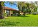 Spacious backyard with lush green grass and a large tree providing shade at 6241 Timberlake Dr # D7, Sarasota, FL 34243