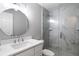 Clean bathroom with a round mirror, white vanity, and a walk-in shower at 6241 Timberlake Dr # D7, Sarasota, FL 34243