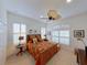 Cozy bedroom showcasing a wicker bed frame, shuttered windows, and a lighted ceiling fan at 12240 Thornhill Ct, Lakewood Ranch, FL 34202