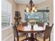 Charming dining area with a round table, stylish chandelier, and view of the outdoor living space at 12240 Thornhill Ct, Lakewood Ranch, FL 34202