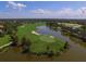 Beautiful aerial image of a golf course with a pond, palm trees and well-maintained greens at 12240 Thornhill Ct, Lakewood Ranch, FL 34202