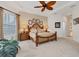 Comfortable main bedroom features carpeted floors, ceiling fan, and decorative wall art at 12240 Thornhill Ct, Lakewood Ranch, FL 34202