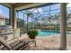 Resort-style covered patio with a built-in grill, a seating area, and tranquil views of the pool at 12240 Thornhill Ct, Lakewood Ranch, FL 34202