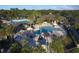 Aerial view of a community pool with lounge chairs and umbrellas with a clubhouse nearby at 12240 Thornhill Ct, Lakewood Ranch, FL 34202