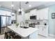 Modern kitchen with white cabinets, island, and stainless steel appliances at 12640 Coastal Breeze Way, Bradenton, FL 34211