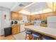 Well-equipped kitchen featuring wood cabinets and an island with bar stools at 1565 Piedmont Rd, Venice, FL 34293