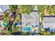 Aerial view of a property with pool, patio, and meticulously landscaped grounds surrounded by lush greenery and mature trees at 5341 Siesta Ct, Sarasota, FL 34242