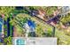 Aerial view of a beautifully landscaped backyard, patio with lounge chairs, and screened-in pool at 5341 Siesta Ct, Sarasota, FL 34242