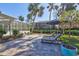 Backyard patio with sun loungers and lush tropical landscaping at 5341 Siesta Ct, Sarasota, FL 34242