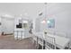 Open concept dining area with white table and chairs, adjacent to the kitchen at 5621 Bidwell Pkwy # 104, Sarasota, FL 34233