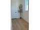 Bright hallway with light wood flooring and a tall potted plant at 8324 Golden Beach Ct, Parrish, FL 34219